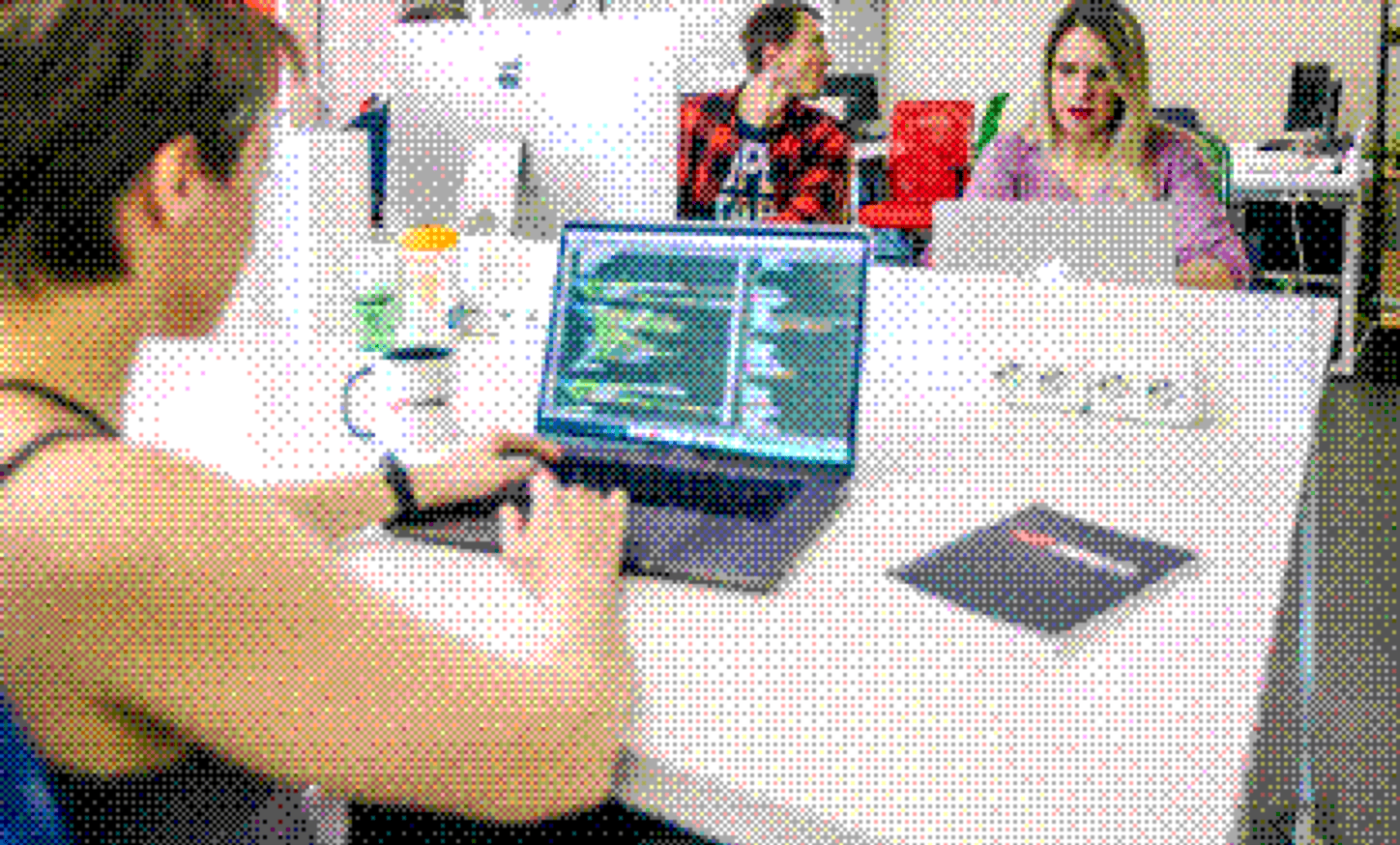 Integrio team members working together on a laptop in the office