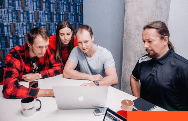 Professionals collaborating around a laptop