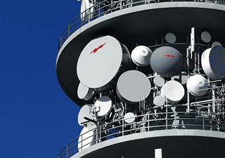 Telecommunications tower with antennas against a blue sky